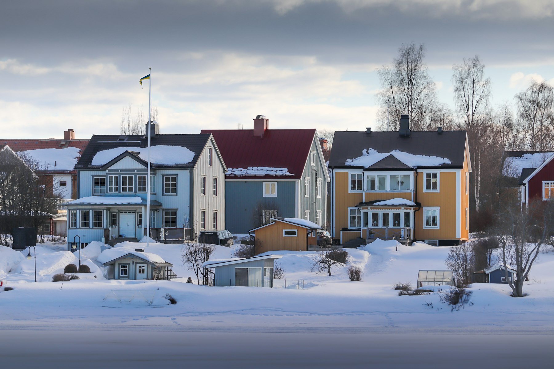 Swedish wooden homes with snow on their roofs in Umeå